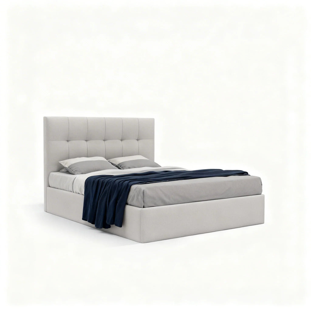 Cama estofada moderna em tecido bege com cabeceira alta, roupa de cama cinza e manta azul escura.